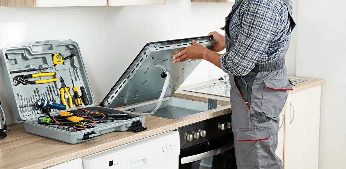 Handyman repairing a cooktop and checking wiring connections in Aurora, CO