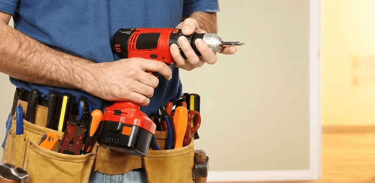 Handyman holding a power drill for home repairs and installations in Aurora, CO